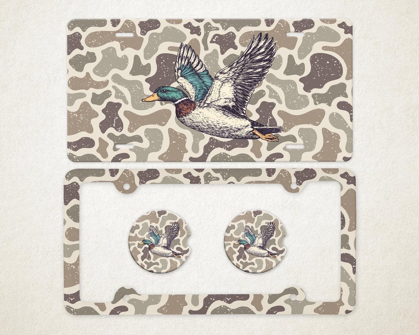 May include: A license plate, license plate frame, and two car coasters with a camouflage pattern. Each item features a detailed illustration of a flying duck with teal, blue, and yellow accents.