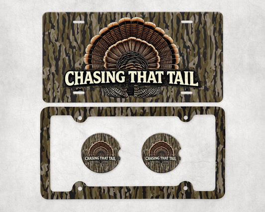 May include: A license plate and car accessories set with a camouflage pattern. The license plate features a turkey tail design and the text "CHASING THAT TAIL". The set includes a license plate frame and two matching car coasters.